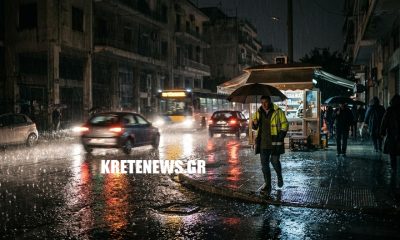Έντονη βροχόπτωση σε δρόμο του Ηρακλείου Κρήτης, με βρεγμένο οδόστρωμα, οχήματα και σκοτεινό ουρανό.