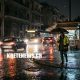 Έντονη βροχόπτωση σε δρόμο του Ηρακλείου Κρήτης, με βρεγμένο οδόστρωμα, οχήματα και σκοτεινό ουρανό.